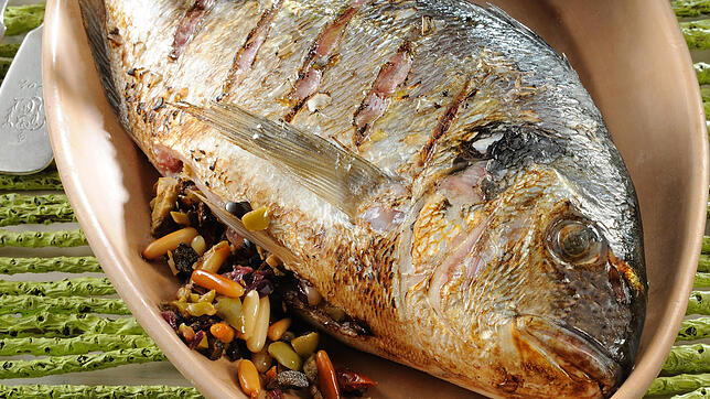 Eine ganze Dorade gelingt auch Fischgrill-Anfängern meist gut. Diese hier ist nicht mit Datteln, sondern mit Oliven gefüllt. Bild: dpa