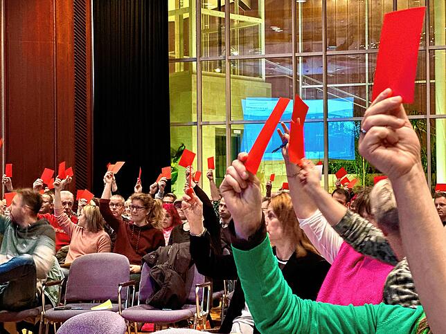 Viele rote Karten machten das Stimmungsbild der Besucher im Saal zu Beginn der Veranstaltung deutlich.