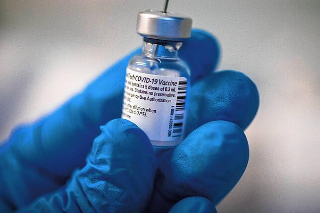 Ein Arzt bereitet mit Schutzhandschuhen den Corona-Impfstoff von Pfizer-Biontech vor. Wie umfassend wird der Schutz?