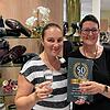 Jasmina Bressel (links) und Jutta Weißer stoßen in den frisch renovierten Räumlichkeiten auf 50 Jahre Schuhhaus Duldinger an.