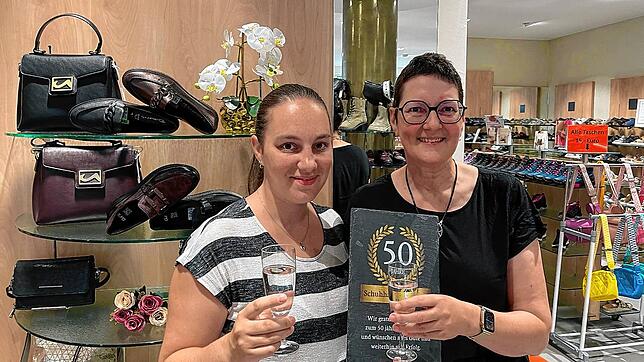 Jasmina Bressel (links) und Jutta Weißer stoßen in den frisch renovierten Räumlichkeiten auf 50 Jahre Schuhhaus Duldinger an.
