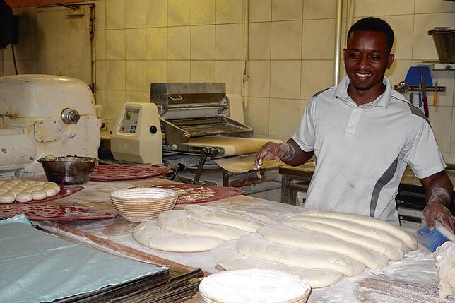 Bäckergeselle Yerro Bah macht seine Arbeit mit viel Leidenschaft. Hier formt er gerade klassische Brötchen.