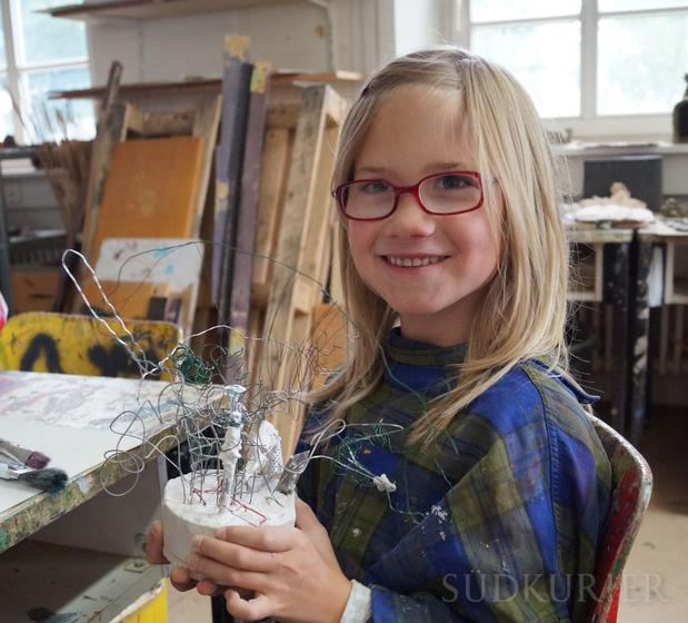 Jette Käfer zeigt ihre im Kinder-Kunst-Workshop selbst gebaute Metall-Skulptur.