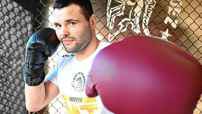Kickboxer Dimitrios Sapanazidis mit unterschiedlich schweren Handschuhen. Die Schweren (rot) sind fürs Training, die Leichten für den Kampf.