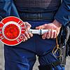 Ein Polizist hält eine Halte-Kelle.