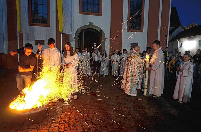Osterfeuer brennen in der Osternacht vor den Kirchen als Symbol für das österliche Heilsgeschehen: Vor der katholischen Pfarrkirche ...