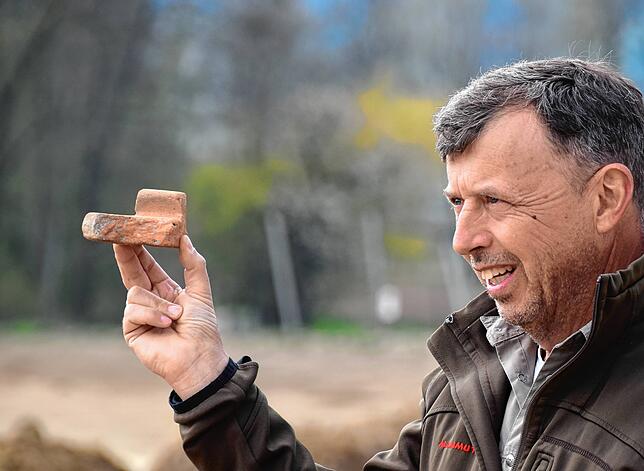 Jürgen Hald zeigt einen Teil eines Leistenziegels aus der Römerzeit.