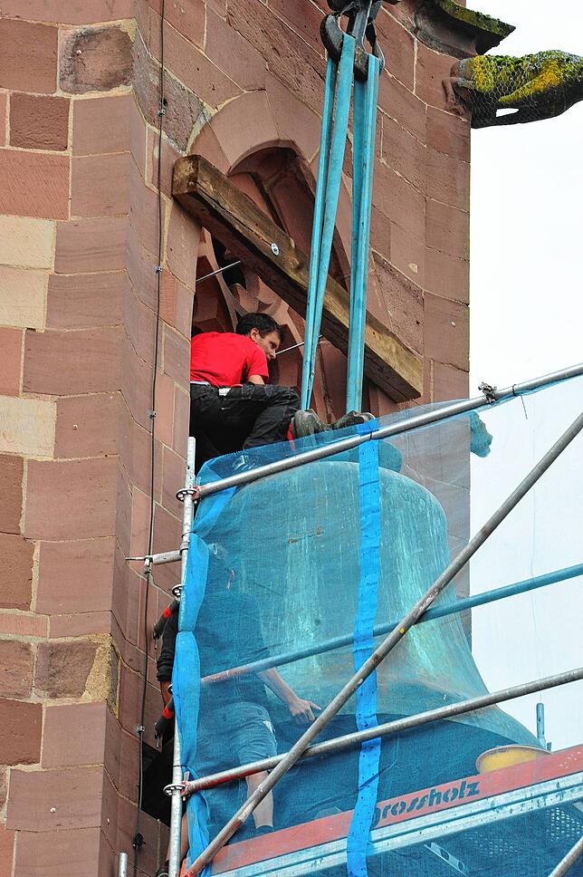 Hier sieht man, wie die Glocke schon fast komplett aus dem Turm manövriert wird.