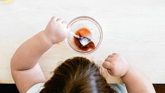 Ein Kind sitzt am Tisch und isst. Im ersten Corona-Jahr sind in Niedersachsen weit mehr Grundschüler wegen starken Übergewichts ärztlich ...