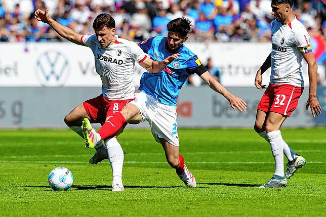 Freiburgs Maximilian Eggestein (l) und Kiels Armin Gigovic kämpfen um den Ball.