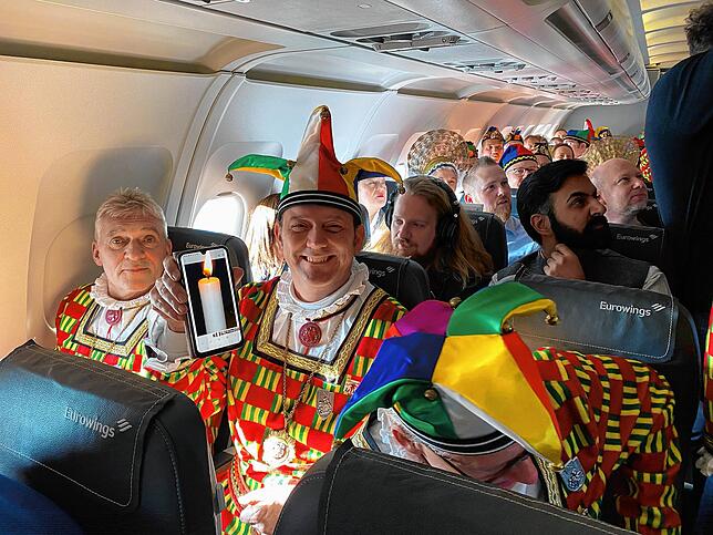 Da im Flugzeug keine Kerzen erlaubt sind, muss eine Kerze auf dem Smartphone für den Laufnarrenschlag her, die Stefan Keil zeigt.