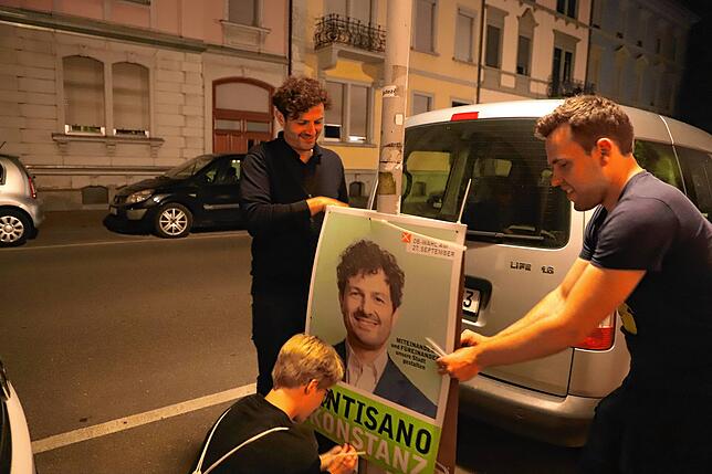 Eingespieltes Team: Während die Nacht voranschreitet, haben die drei Plakatierer die Handgriffe eingeübt.