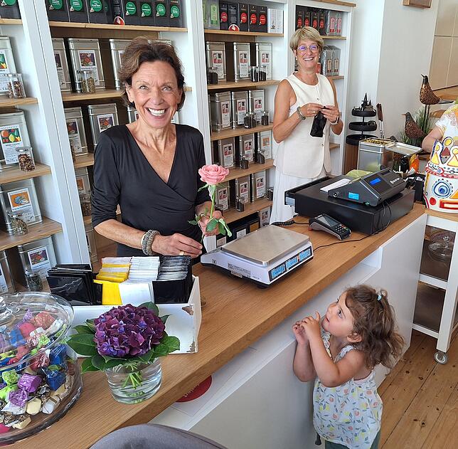 Marga Grießhaber, TeeMa-Inhaberin, erhält von der kleinen Emma eine Rose zum Neustart in der Villinger Rietstraße.