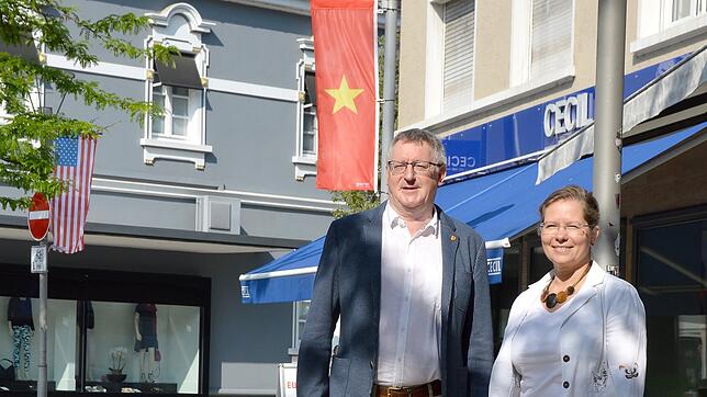 Bürgermeisterin Diana Stöcker und Kulturamtsleiter Claudius Beck an der Flagge von Vietnam. Auf der anderen Straßenseite weht dagegen ...