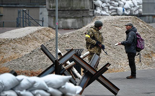 Ein Mitglied der Ukrainischen Territorialen Verteidigungskräfte überprüft am 7. März im Zentrum von Kiew zwischen Panzersperren die ...
