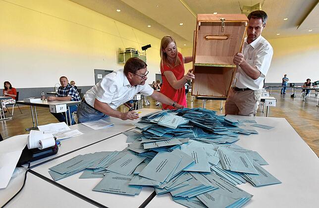 Raimund Zeller (links), Carina Kehm und Wahlleiter Clemens Knoblauch schütten eine der Urnen aus.