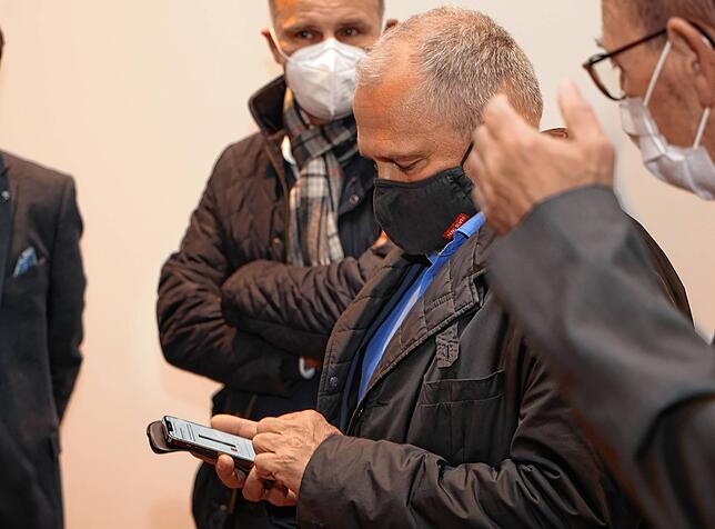 Blick auf das Mobiltelefon, dass ihm eine erhebliche Wahlniederlage bestätigt. OB Martin Staab im Kreis der Kollegen Bernd Häusler und ...