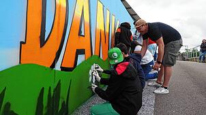 Fabian Bielefeld (r.) sprayt mit Schülern der Eichendorff-Schule Abfallmonster auf die Wände des Recyclinghofs Herten. Foto: Boris Burkhardt