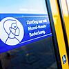 Ein Schild mit der Aufschrift &bdquo;Zustieg nur mit Mund-Nasen-Bedeckung.&ldquo; klebt an der Zugtür einer Regio-S-Bahn.