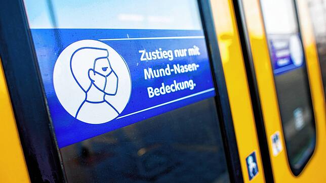 Ein Schild mit der Aufschrift &bdquo;Zustieg nur mit Mund-Nasen-Bedeckung.&ldquo; klebt an der Zugtür einer Regio-S-Bahn.