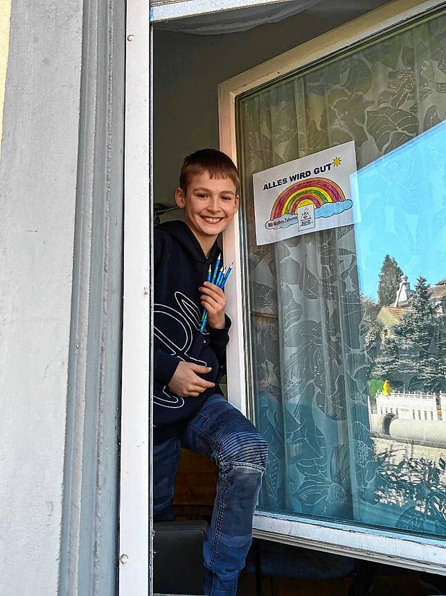 Lukas Weiß mit seinem Regenbogenbild am Fenster in der Fürstenbergstraße.