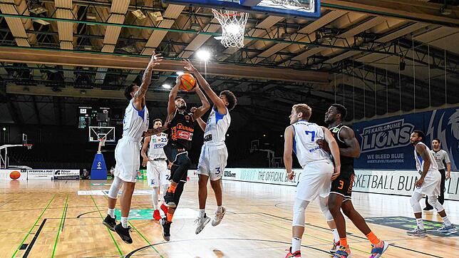 Hart bedrängt von zwei Karlsruhern, setzt Panthers-Spieler Nate Britt zum Wurf an.