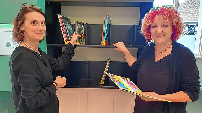 Bibliotheksleiterin Yvonne Radzuweit (links) und Kulturamtsleiterin Kerstin Simon stehen vor dem sogenannten intelligenten ...