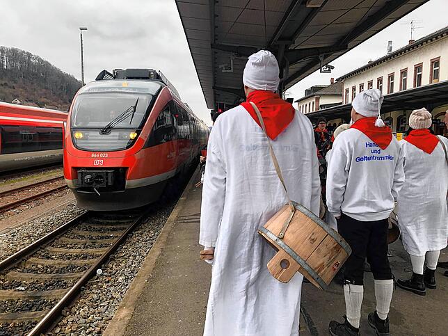 Mitglieder der Narro-Zunft Waldshut wartet am Waldshuter Bahnhof auf den Zug, der sie zum Narrentreffen nach Dogern bringt.