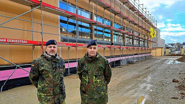 Kasernenfledwebel Alexander Sude (links) und Kasernenkommandant Tobias Lang vor der Fassade der neuen Bundeswehr-Sporthalle.