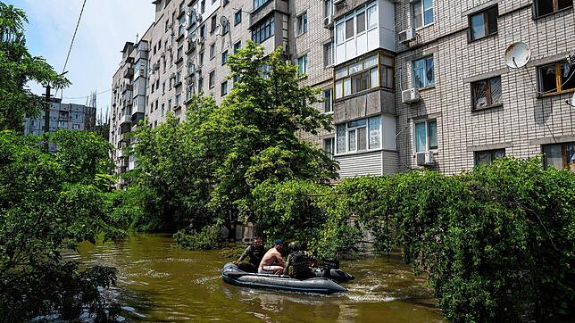 Folgen des Dammbruchs: Ukrainische Soldaten evakuieren einen Mann in einem Boot aus einem überfluteten Stadtteil von Cherson.