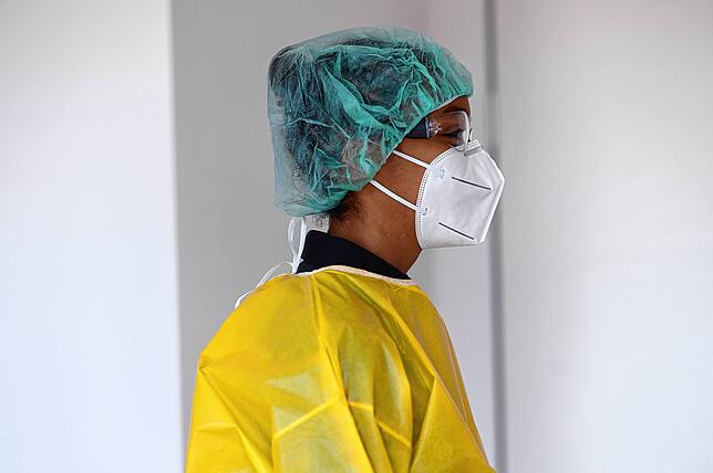 Hygienevorführung beim Deutschen Roten Kreuz:Haarnetz über die Ohren: So werden die Gummis der Maske an der Stelle weniger kontaminiert, ...