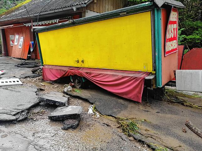 Auf dem Vorplatz des Obststands ist der Asphalt abgeplatzt. Die Feuerwehr fürchtet einen weiteren Erdrutsch, der das Häuschen einstürzen ...