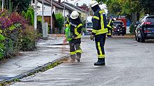 In der Fichtenstraße bringt die Feuerwehr Mönchweiler von Hand Ölbindemittel aus.