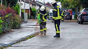 In der Fichtenstraße bringt die Feuerwehr Mönchweiler von Hand Ölbindemittel aus.