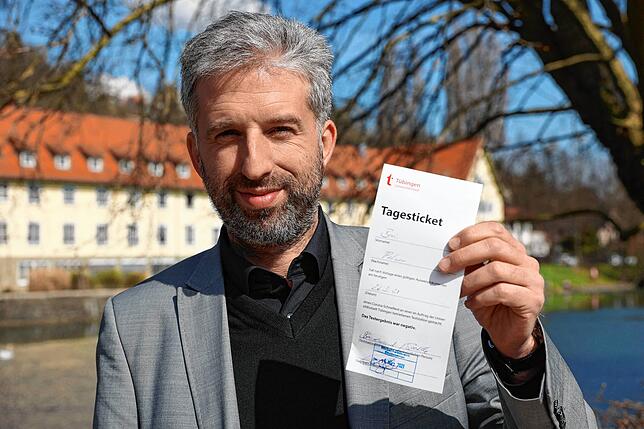 Oberbürgermeister Boris Palmer zeigt ein „Tagesticket“ in Papierform, mit dem Bürger Zutritt zu Läden und ...