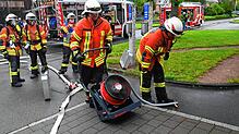 Vor dem Ende der Übung bringen Kameraden der Feuerwehr einen Hochleistungslüfter in Stellung, um den Rauch aus dem Gebäude zu blasen. ...