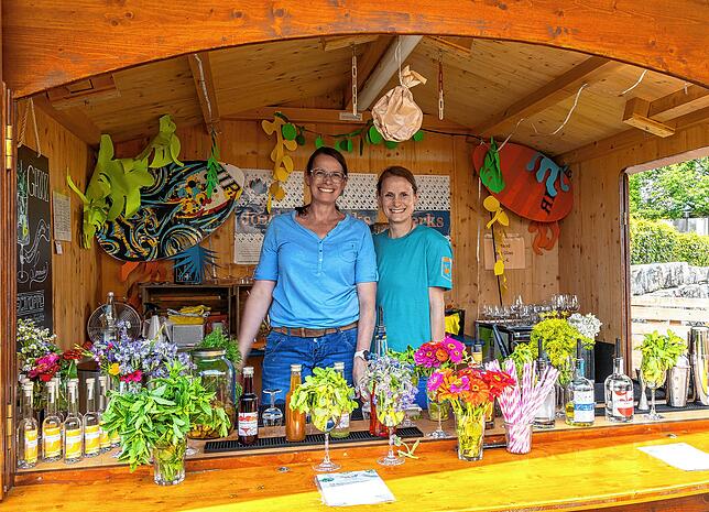 Die beiden gut gelaunten Frauen an diesem Getränkestand präsentieren ihren Gästen eine bunte Auswahl.