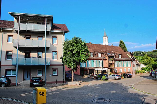 Das alte Rathaus in Weizen (links), das Gasthaus &bdquo;Kreuz&ldquo; (rechts) und dahinter die Kirche St. Konrad in Weizen.