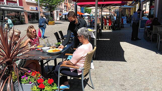Mit Mundschutz: Gäste bekommen ihr Mittagessen am Dienstag im Außenbereich des Gasthaus Löwen in der Oberen Straße in Villingen ...