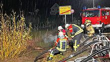Feuerwehrleute pumpen unter Hochdruck Wasser ab.