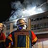 Zwei Feuerwehrmänner beobachten die Löscharbeiten an der Robert-Gerwig-Schule. Dort ist in der Nacht von Montag auf Dienstag ein Feuer ...
