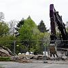 Der Abrissbagger mit seinen großen Zähnen gräbt sich durch den Boden auf dem Baugrundstück, auf dem bald ein elfgeschossiges Hochhaus ...