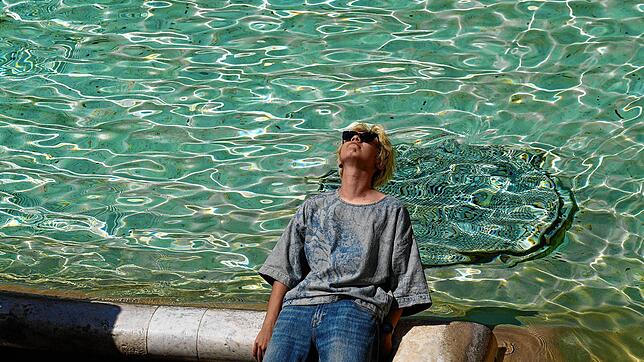 Ein Mann sitzt am Trevi-Brunnen in Rom, während die Temperaturen bis zu 39 Grad Celsius erreichen. Ein Bad wäre gar nicht so schlecht.