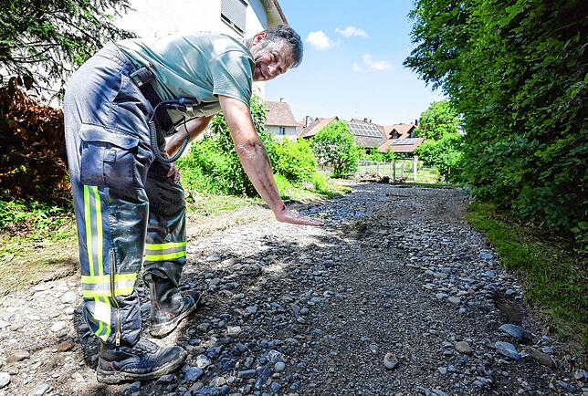 Gesamtkommandant Thomas Renz zeigt: So hoch stand das Wasser auf der Straße