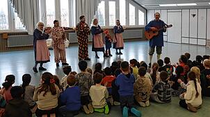 Sechs Mitglieder der Poppele besuchten die Waldeck-Schule in Singen und stellten die Traditionen ihrer Zunft vor.