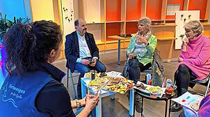 Bei Plätzchen und Glühwein tauschen sich die Pop-up-Store-Betreiber aus dem Jahr 2024 gemeinsam mit Bürgermeister Josef Herdner über die ...