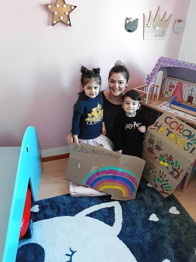 Neben dem Regenbogenbild hat Familie Usta noch ein weiteres Bild mit ihren Handabdrücken gemalt (rechts im Bild). Der Schriftzug ist in ...