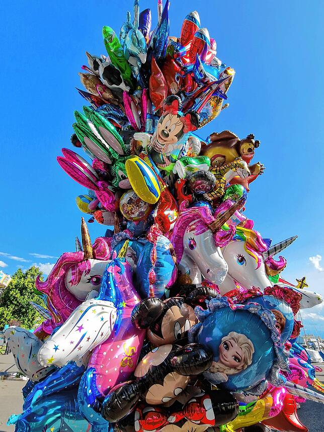 Bunte Luftballons werden auf dem Festgelände angeboten.