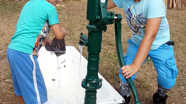 Erfrischung: An heißen Tagen ist das kühle Wasser aus dieser Pumpe eine willkommene Abkühlung für die Kinder, hier Maxim (links) und ...