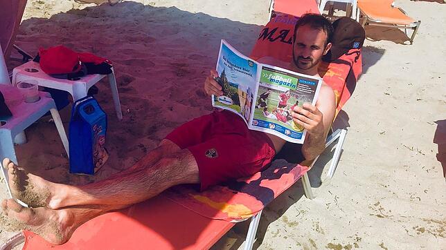Entspannt am Strand: Mit der richtigen Lektüre, dem neuen SÜDKURIER-Fußballmagazin, erholt sich Marco Lohr vom SV Jestetten in Griechenland.